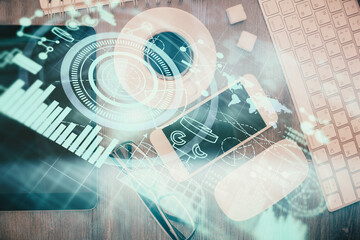 Double exposure of business theme hologram over desktop with phone. Top view. Mobile international...