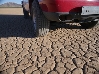 A truck parked on a dry lake bed in the desert