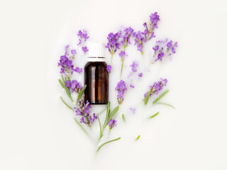 A bottle with essential oil and a bouquet of lavender in a milk bath. Natural cosmetic. Top view, flat lay, mock up.