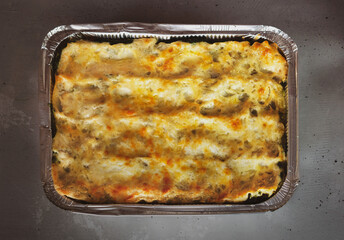 homemade lasagna in a baking dish on a gray background