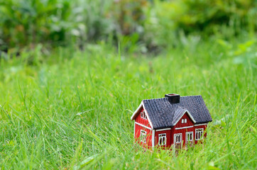 red small house model on the grass, housing concept