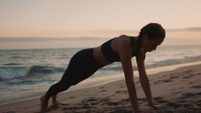Pro Athlete woman working out on the beach in Malibu, California while enjoying an incredible sunset and views to the pacific ocean