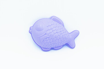 Beach toys: a fish shaped sand mold on a white background