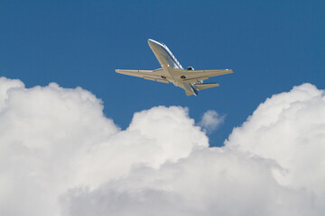 Fototapeta na wymiar Corporate Jet Flying Above Clouds