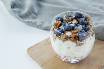 Fototapeta na wymiar Healthy blueberry and walnut parfait in a glass on a white background