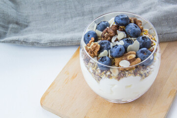 Healthy blueberry and walnut parfait in a glass on a white background