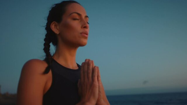 Portrait of woman breathing deeply and meditating at ocean coast, namaste greeting to a sunset, concentration and mind setting for yoga session