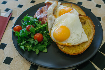 fried eggs with bacon and vegetables