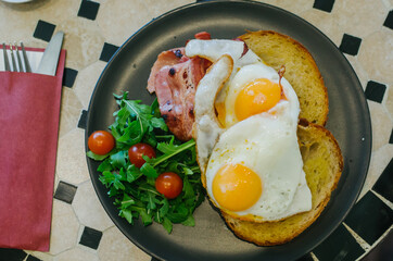 fried eggs with bacon and vegetables