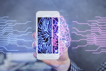 Double exposure of man's hand holding and using a digital device and brain hologram drawing. Data...