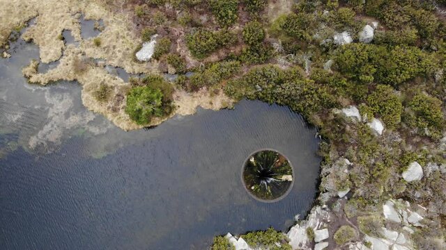 Aerial shot of big sinkhole constructed as a water spillway at Covao dos Conchos dam lake in Serra da Estrela