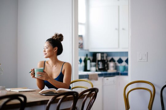 Young Asian woman working from home on kitchen dining table