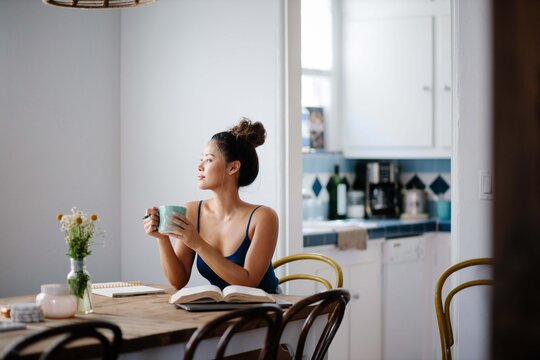 Young Asian woman working from home on kitchen dining table