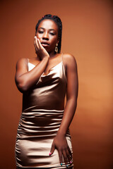 pretty young african american woman with braids posing cheerful gesturing on brown background, lifestyle people concept