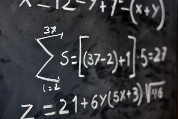 Ecuaciones matemáticas escritas a mano con una tiza blanca en la pizarra	