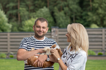 Lifestyle, a happy couple of men and women walking on a Sunny day outdoors with a dog cavalier king...
