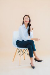 Portrait beautiful young business asian woman sit on chair with laptop or smart phone