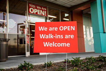 Sign in front of hair salon stating We Are Open Walk-Ins are Welcome 
