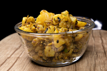 Boiled Potato mixed with Spices herbs like Mint and Cumin Powder Indian Tasty Cuisine Aloo Ki Sabji in Indian Homes filled in Transparent Glass Bowl Served with Wheat Bread macro shot