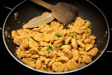 Gattey ki sabji Indian Delicious Cuisine of Rajasthan made with Roasted Boiled Gram Flour mixed with Seasame Seeds and Cumin Seeds in Glass bowl and Frying Pan decorated with Leaf Spatula