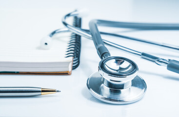 Medical stethoscope for doctor checkup and notepad on table