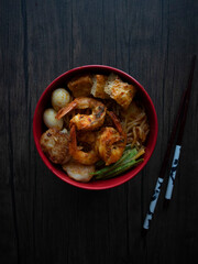 Singapore Dry Laksa Flatlay. Singapore Laksa Top Down Shot on Wooden Table with Copy Space. Dark Food Photography.
