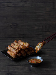 Singapore Ngoh Hiang (Chinese Five-Spice Pork Roll) on Wooden Background with Copy Space. Peranakan Ngoh Hiang with Chili Still Life Rustic Shot.