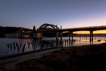 Beautiful historic Siuslaw river bridge in Florence, Oregon, in dusk. Sunset glow reflects in water