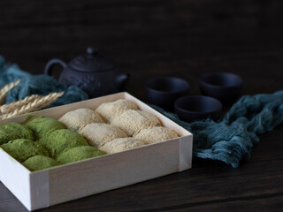 Matcha Daifuku Mochi (Green Tea Mochi With Red Bean Fillings). Green Tea Daifuku on Dark Background with Copy Space. Still life, dark food photography of Warabi Mochi.