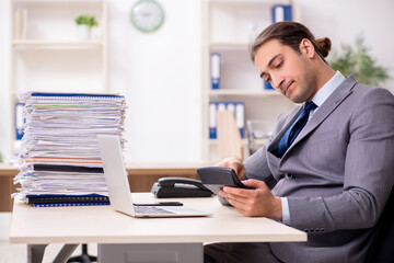 Fototapeta premium Young male businessman unhappy with excessive work