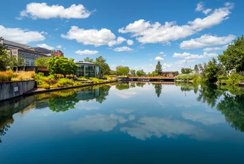 Fotobehang The summer blue sky with clouds reflects off of the Spokane River at Riverfront Park in downtown Spokane, Washington, USA © Kirk Fisher