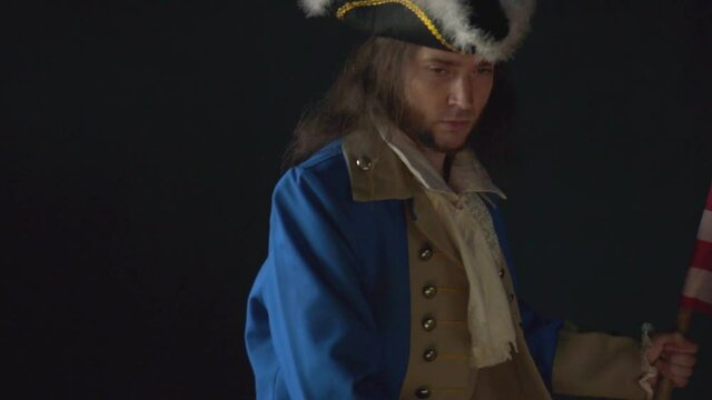 Officer in uniform of US Revolutionary War with pistol on black background. Historical concept