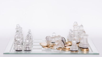 Tablero de ajedrez con piezas transparentes en formación de juego con monedas doradas