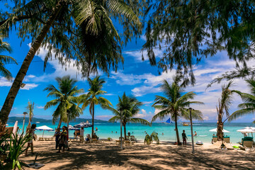 フィリピン・ボラカイ島のホワイトビーチにて、ヤシの木の間から青空を眺める