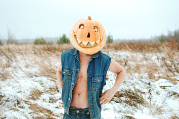 man in a denim jacket wearing a naked body with a Halloween pumpkin on his head, celebrating Halloween