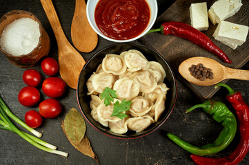 Russian boiled dumplings on a dark table . Traditional dish of Russian cuisine .