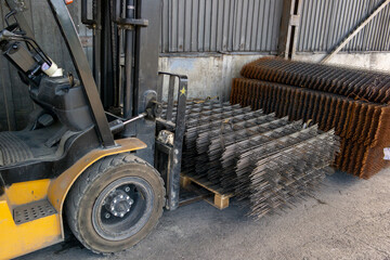 forklift carrying a stack of rebar mesh © zettar