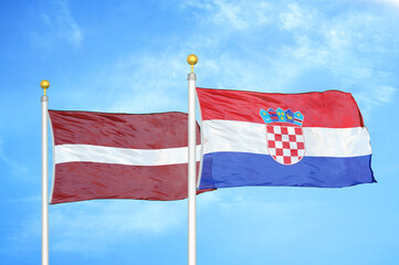 Latvia and Croatia two flags on flagpoles and blue sky