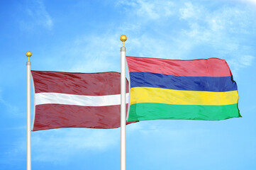 Latvia and Mauritius two flags on flagpoles and blue sky