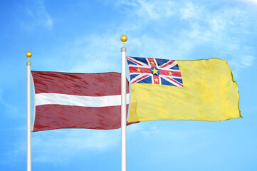 Latvia and Niue two flags on flagpoles and blue sky