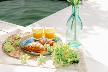 Morning breakfast with croissants by the pool