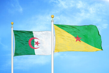 Algeria and French Guiana two flags on flagpoles and blue sky