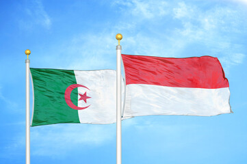 Algeria and Indonesia two flags on flagpoles and blue sky