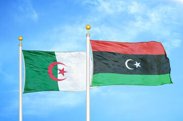Algeria and Libya two flags on flagpoles and blue sky
