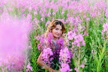 Outdoor portrait of a beautiful middle aged blonde woman in a field with flowers