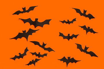 decoration concept for Halloween.  Black paper bats fly in  directions on an orange background.  template