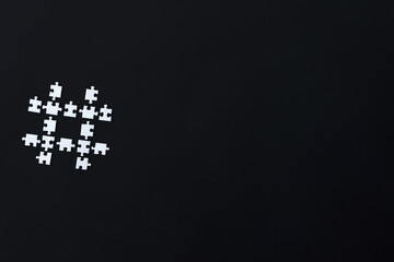 Hashtag icon laid out from white pieces of puzzles on black background. Number sign for reading social media messages, indicating start. Using, surfing, searching on internet, blogging concept.