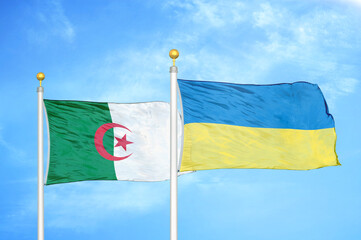 Algeria and Ukraine two flags on flagpoles and blue sky