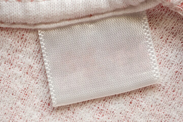 White blank laundry care clothes label on cotton shirt background