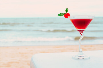 Summer cocktail with tropical beach on background.